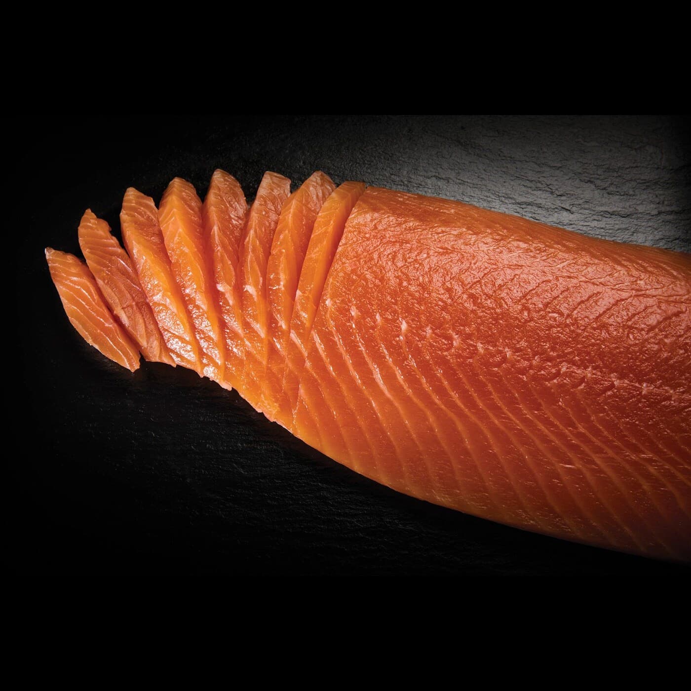 Filetto di salmone affumicato Upstream affettato su ardesia